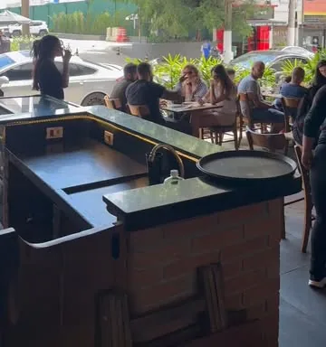 Balcão escuro do salão com mesas e clientes ao fundo